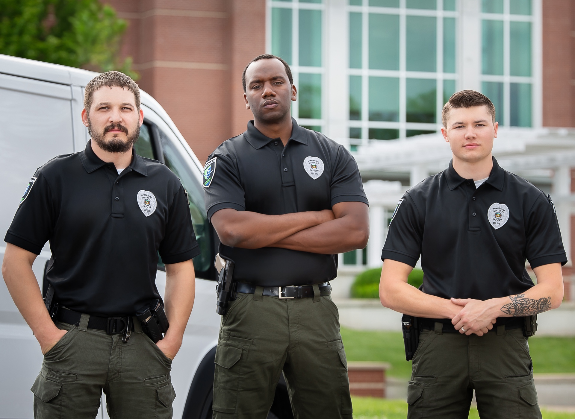 Three uniformed employees from 5th Meridian Group standing together, representing professionalism and dedication in security services.