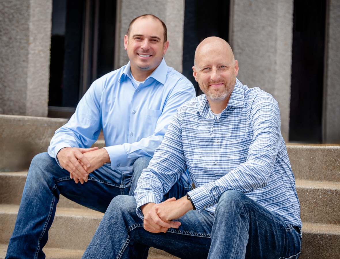 Two men from 5th Meridian Group sitting outdoors, reflecting a commitment to teamwork and community-focused security services.