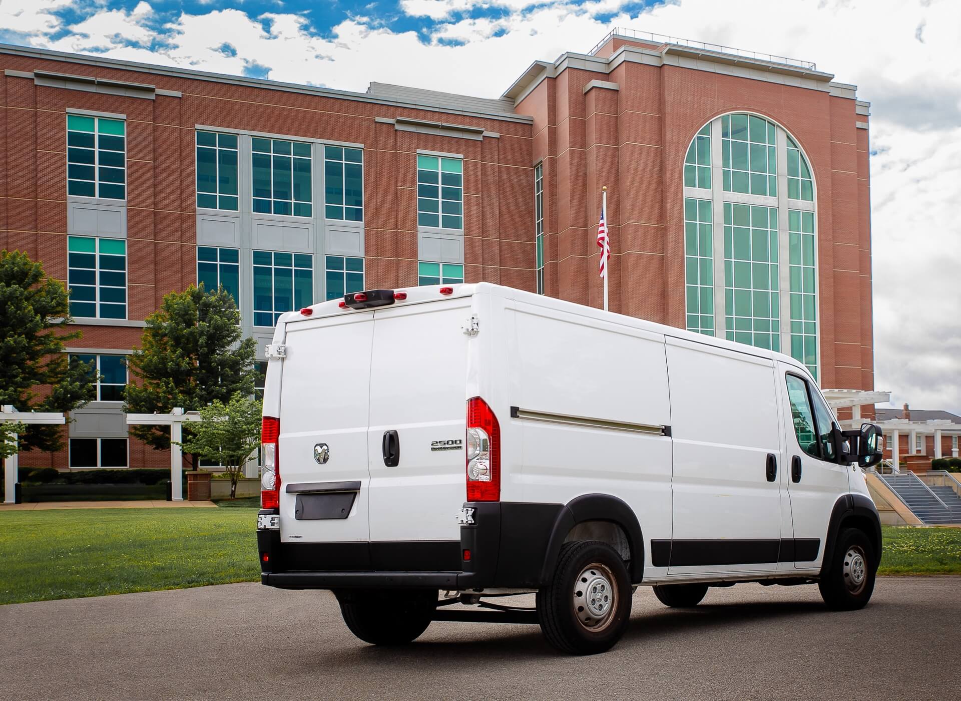 A white van parked against a brick building, showcasing 5th Meridian Group’s commitment to secure transportation and logistics services.